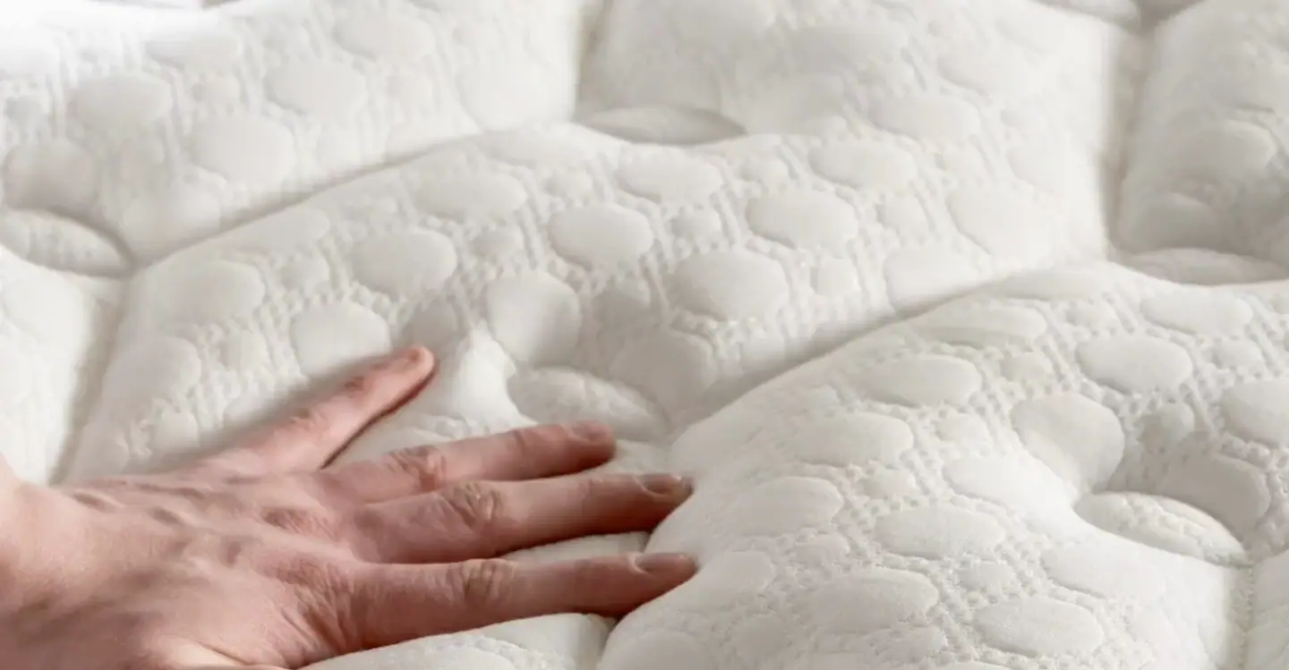 A hand pressing the quilted top of an Arthur Sleep mattress, from Mattressman's own product film